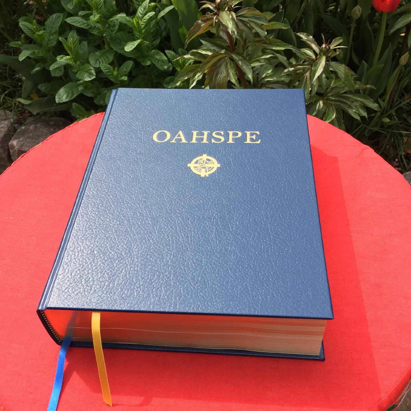 A copy of Oahspe sitting on a table in a garden.